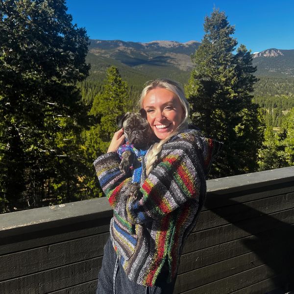 Maddy with her dog on a mountain deck